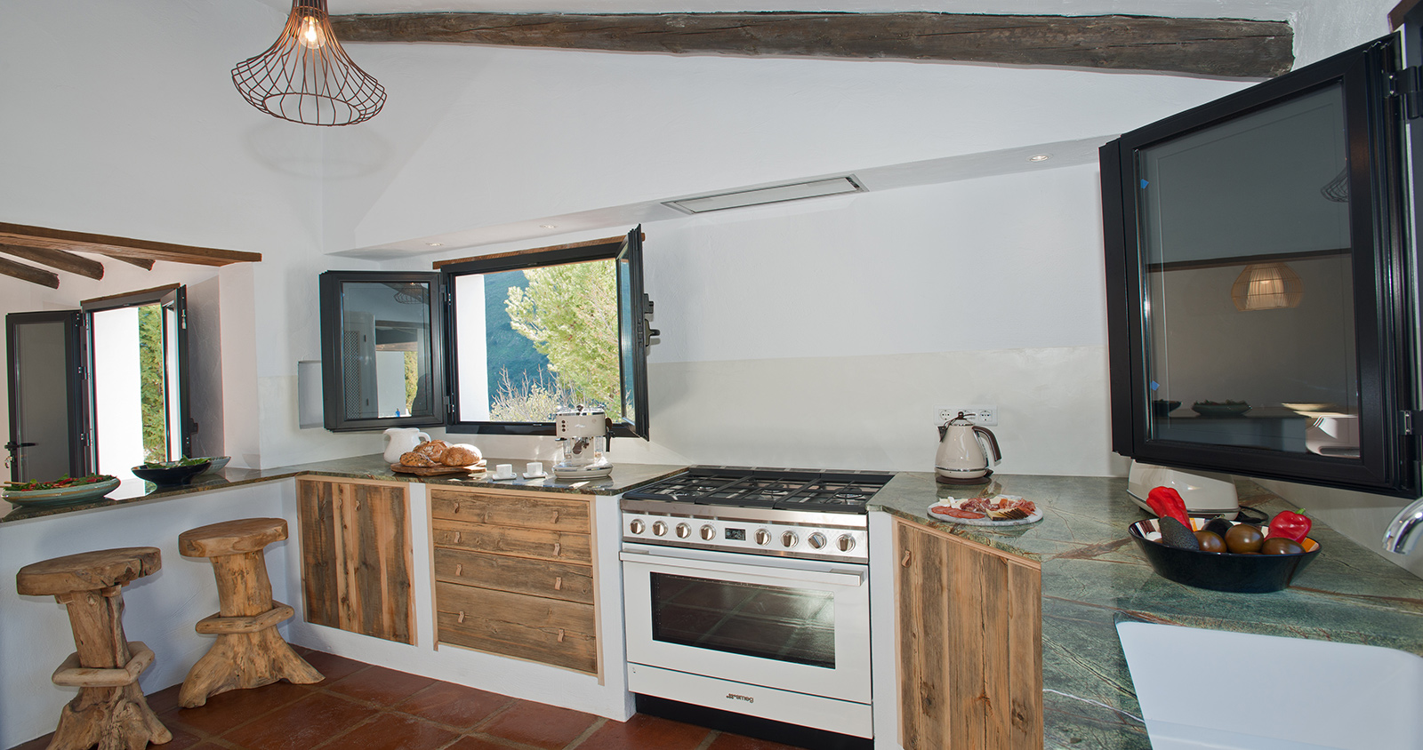 Open keuken met houten kasten en stenen vloer