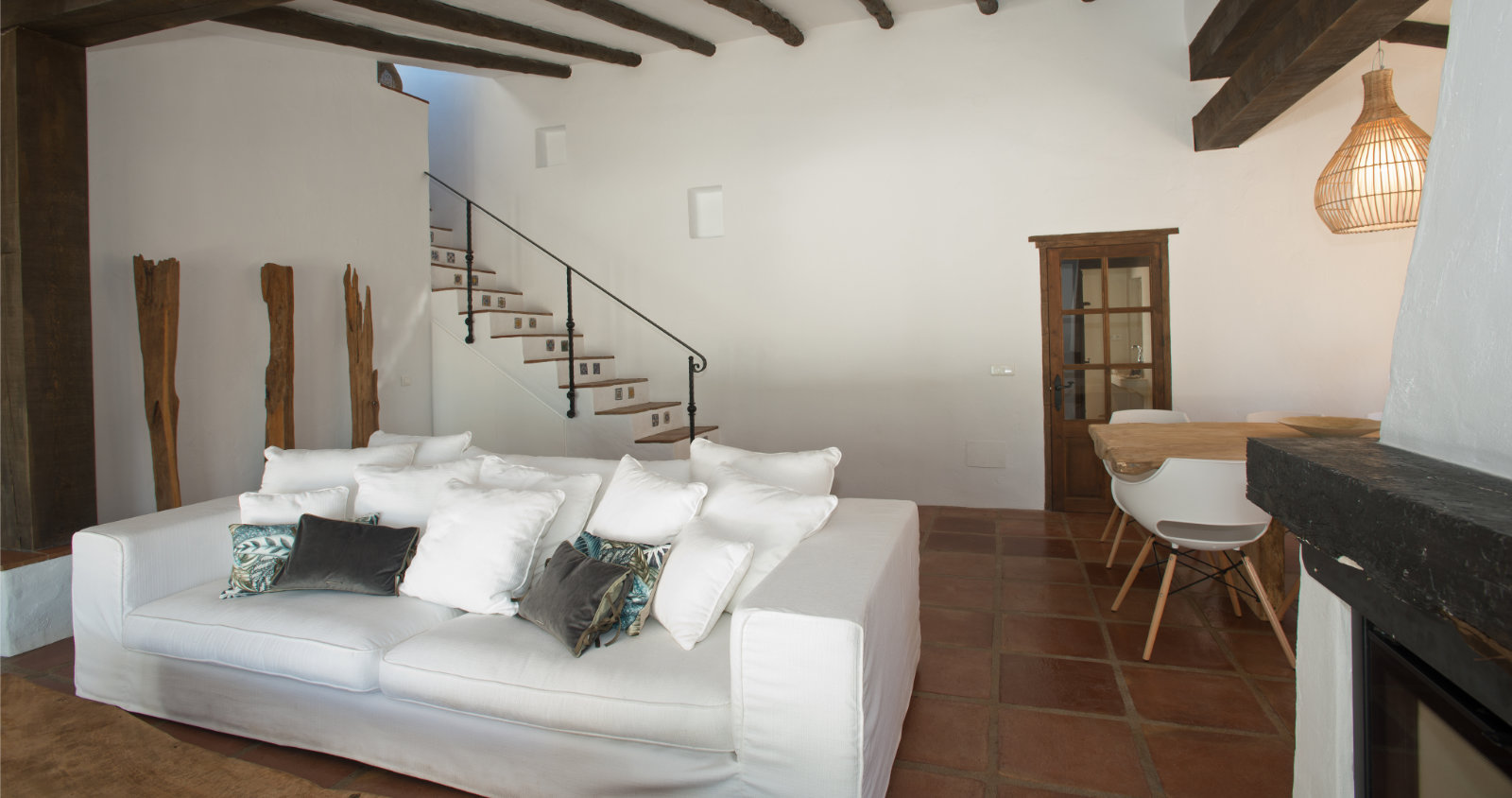 Woonkamer met witte zetel en trap