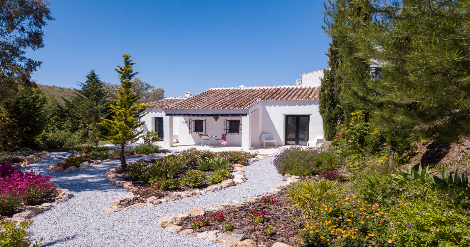 Casita met bloementuin en grindpad
